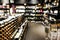Blurred wine section of retailer with bottles on shelf display rack