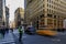Blurred yellow taxi cabs speed past people and traffic cop at a busy crossing on 5th Avenue in Manhattan, New York, USA