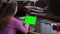 Blurred young woman sitting on the left typing on green screen laptop keyboard. Confident concentrated Caucasian