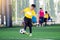 Blurry ball with Asian kid soccer player speed run to shoot ball to goal on artificial turf