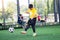 Blurry ball with Asian kid soccer player speed run to shoot ball to goal on artificial turf