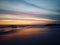 Blurry beach landscape background. Colorful sunset sunrise backgrounds. Dramatic sky colors over horizon. Blurry wave motion.