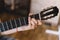 Blurry closeup of a man playing the wooden guitar. Focus on the guitar