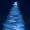 Blurry creative lighted christmas tree in monochrome classic blue palette on a dark background in trendy color of 2020. Xmas and