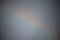 A blurry gray background of obscured rainbow visible.