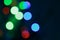 Blurry holiday lights on a christmas tree at night, dark background, new year