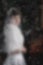 Blurry image -a bride in a white dress and veil in a church.