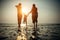 Blurry image of family couple with small baby against sunset on the sea. Family idyll, silhouettes of husband, wife and small