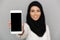 Blurry image of smiling muslim woman 20s in islamic headscarf wi