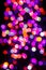 Blurry indistinct image of multicolored holiday lights at night.