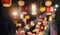 Blurry photography image show variety of Chinese lanterns hanging from the ceiling with bright decorating light on atmosphere of