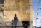 Blurry reflection shadow silhouettes of a woman and a child walking on a wet street on a sunny summer day