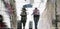 Blurry reflection silhouette on wet city street of two tourist  people walking under umbrella
