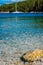 Blurry sail boat docked alone in emerald hidden lagoon among picturesque mediterranean nature Ionian Islands, Greece