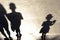 Blurry shadow silhouette of a children walking on a promenade on a summer day