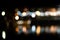 Blurry shot of a city scenery with lights reflecting in the river during nighttime