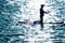 Blurry silhouette of a man paddling in the sea