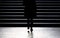 Blurry silhouette of young woman climbing up the city street sta