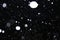 Blurry snow in the night sky. Blurry white snowflakes on a dark background. Abstraction photo.