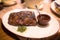 Blurry view of fried beef steak on table with sauce