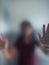 Blurry woman hand behind frosted glass metaphor panic