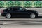 BMW 5 series on the road in motion. Black shiny sedan moving fast. Side view of premium car with blurred background