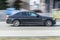 BMW 5 series on the road in motion. Fast speed drive on city road with blurred background