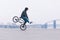 BMX bicycle rider rides on the front wheel against the background of the minimalistic urban landscape.BMX concept