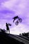 BMX bike jumping in sky on high speed, black silhouette against bright sky. Extrem Sport and risk.