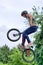 BMX freestyle teenage biker jumping in air