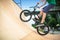 Bmx rider jumping over on a U ramp in a skatepark