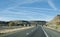 BNSF train approaches a highway bridge in eastern New Mexico