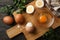 Board with boiled eggs, napkin and parsley on wooden background