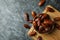 Board with bowl of dried dates on black smokey background