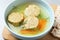 Board with bowl of Jewish matzoh balls soup on table