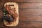 Board with cocoa pods, beans and powder on wooden table, top view