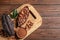 Board with cocoa pods, beans and powder on wooden table, top view with space for