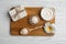 Board with cosmetic products and Shea butter on table