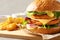 Board with double vegetarian burger and fried potatoes on table