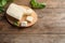 Board with feta cheese and basil on wooden background, top view. Space for
