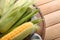 Board with fresh corncobs on wooden table