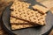 Board with fresh rye crispbreads on table, closeup