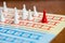 the board game with color pawns, The red chip is in the lead, white competitors.