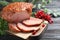 Board with homemade delicious ham on wooden table, closeup. Festive dinner