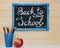 A board with an inscription chalk, back to school, a glass with