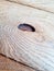 A Board with a knot hole. Wood surface with wavy texture. Close up view
