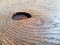 A Board with a knot hole. Wood surface with wavy texture. Close up view