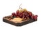 On the board, is layout of grapes, sliced cheese and a handful of hazelnuts. Isolated on white.