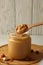 Board with peanut, spoon and jar with peanut butter on white table