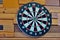 Board for playing darts on a wooden wall close up